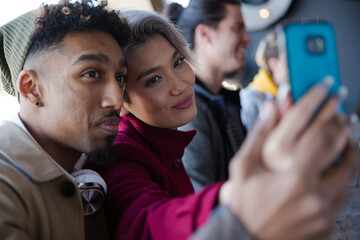 Smiling young couple taking selfie with camera phone