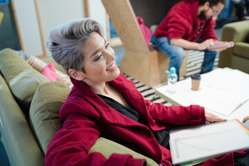 Portrait of woman reviewing paperwork on sofa