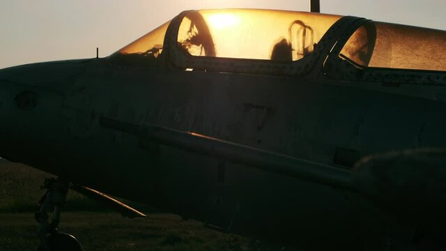 Dark silhouette of old broken Delfin L-29 training aircraft standing at abandoned military air base at sunset close side view