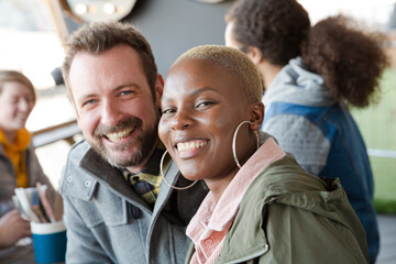 Portrait of smiling couple dining with friends at restaurant outdoor patio