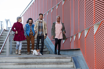 Obraz premium Young friends walking down down urban, modern stairs