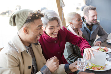 Smiling friends eating at restaurant outdoor patio