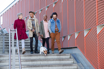 Obraz premium Young friends walking down down urban, modern stairs