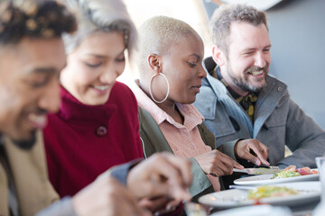 Smiling friends eating at restaurant outdoor patio