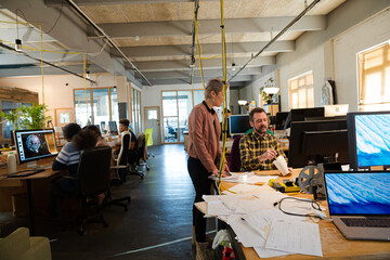 Man and woman discussing paperwork at desk