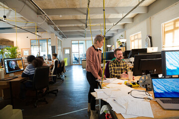 Man and woman discussing paperwork at desk