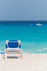 White and blue sun bed lounger laying on the white sand at the beach in mexico mayan riviera cozumel.