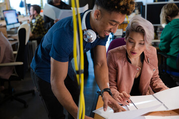 Man and woman discussing paperwork in office