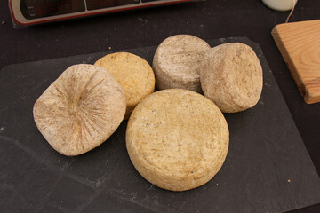 Slate board full of cheeses ready to be cut