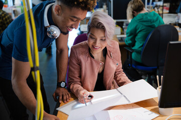 Man and woman discussing paperwork in office