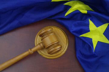 Judge gavel with European Union flag on wooden table. Justice and laws in EU concept.	