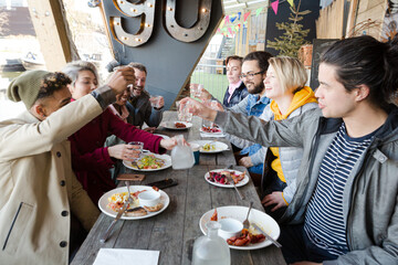 Portrait of smiling friends eating at restaurant outdoor patio