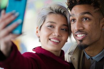 Smiling young couple taking selfie with camera phone