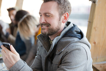 Man using smartphone while dining with friends