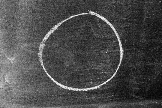 White chalk hand drawing as circle shape on blackboard or chalkboard background with copy space