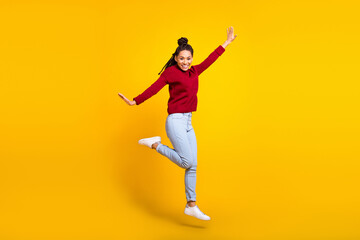 Fototapeta na wymiar Full length photo of adorable sweet dark skin lady wear red pullover smiling jumping high isolated yellow color background