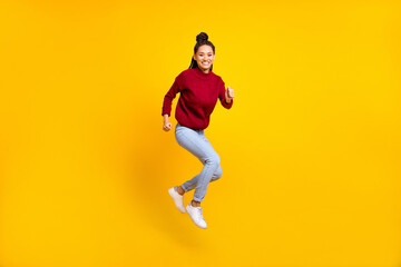 Fototapeta na wymiar Full length photo of cute adorable dark skin lady wear red pullover smiling jumping high isolated yellow color background