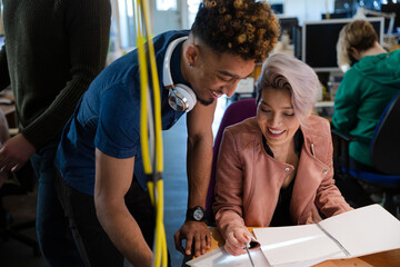 Man and woman discussing paperwork in office