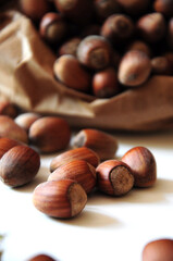 Hazelnut close-up. Hazelnuts in a paper bag on a wooden background. Hazelnut background, healthy food. Corylus. 