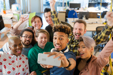 Team talking group selfie with smartphone in office