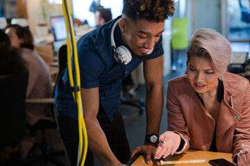 Man and woman discussing paperwork in office