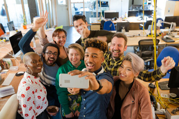 Team talking group selfie with smartphone in office