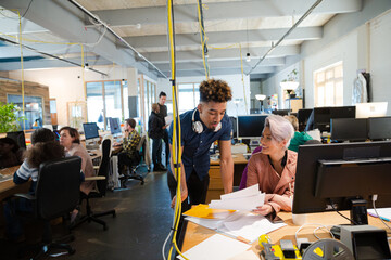 Man and woman discussing paperwork at desk