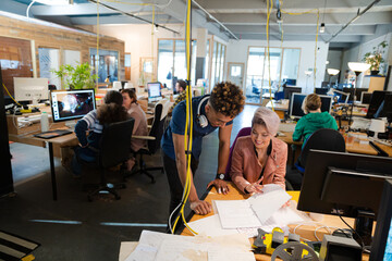 Man and woman discussing paperwork in office