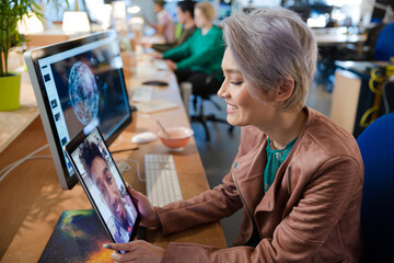 Young woman using tablet computer at desk