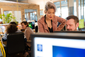 Man and woman discussing paperwork at desk