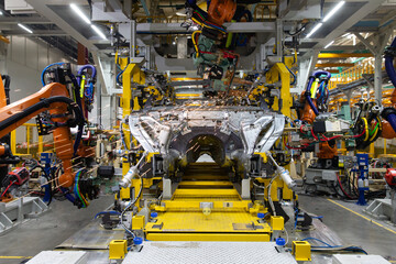 The robot makes welding of the car body. Assembly line.