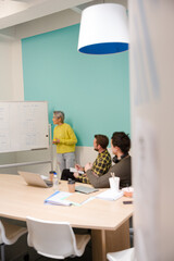 Businesswoman at whiteboard leading conference room meeting