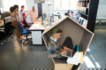 Young man working at laptop in modern armchair