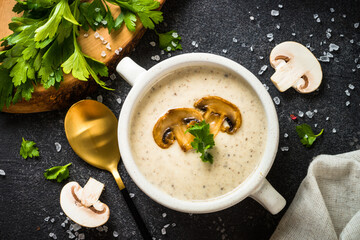 Mushroom Soup on dark stone table. Hot autumn dish, creamy soup.
