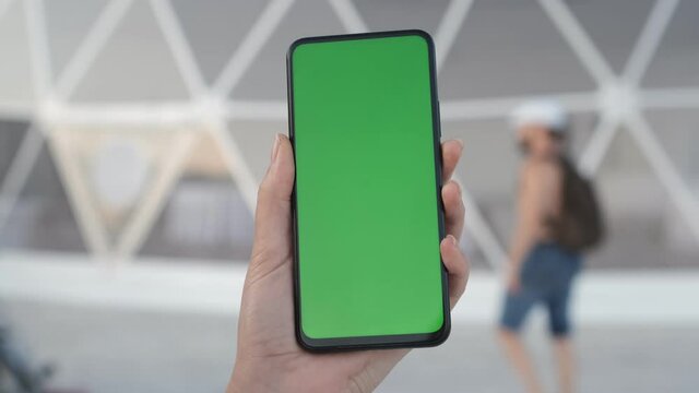 Back View of Woman at Phone with Green Screen for Copy Space. Chromakey Mock Up Without Tracking Markers. 20s Lady Watching Video News on the terrace by the lake Close up
