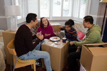 Fototapeta premium Friends taking a break from moving, playing cards