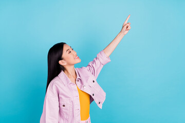 Profile side view portrait of attractive cheerful girl showing copy space ad advert isolated over bright blue color background