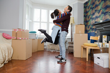 Happy, playful couple moving into new house