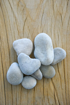 Group of smooth pebbles with one heart shaped on a wooden table