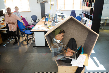 Young man working at laptop in modern armchair