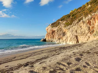 Foto op Canvas Mylos sandy beach with azure vibrant stormy waves in sunset light on coast of Lefkada island in Greece. Summer nature vacation travel to Ionian Sea © Kathrine Andi