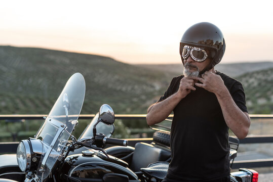 Mature man with sidecar in sunset with her bike