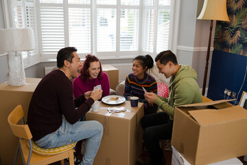 Fototapeta premium Friends taking a break from moving, playing cards