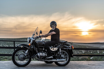 Mature man with sidecar in sunset with her bike