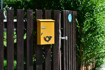 Briefkasten aus Metall an der Grenze zum Vorgarten eines Wohnhauses