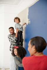 Happy family painting wall