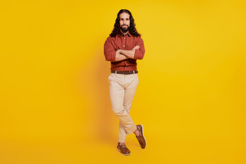 Fototapeta na wymiar Portrait of confident successful handsome guy folded arms posing on yellow background