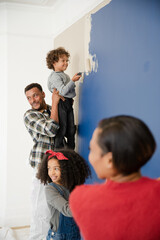 Happy family painting wall