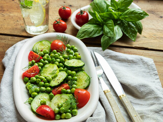 Salad. Fresh vegetable salad with tomato, cucumber, basil, green peas.