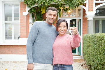 Portrait happy couple with keys to new house